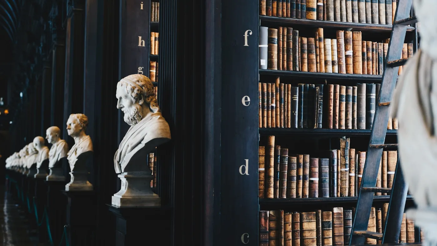Rows of antique leather-bound law volumes on tall dark wood shelving in a historic library